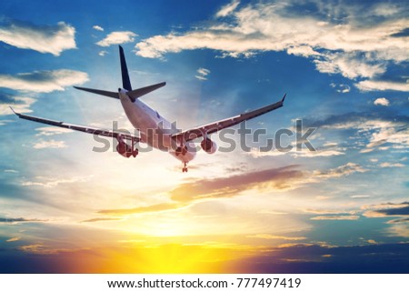 Airplane in the sunset sky flight travel transport airline background concept. Royalty-Free Stock Photo #777497419