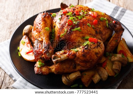 Festive food: fried chicken with mushrooms and potatoes close-up on a plate on a table. horizontal
