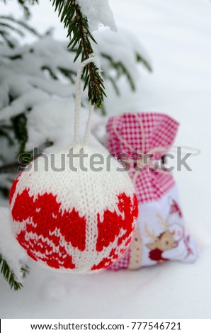 Knitted balls for New Year tree decoration and gift bag spruce and snow background