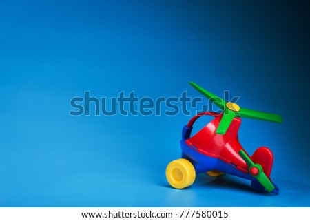 modern plane toy on blue background. colored kids helicopter