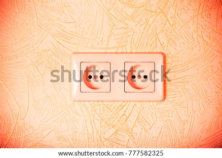 Light wallpaper on a wall with electrical outlet for background. Close Up detail. Toned.