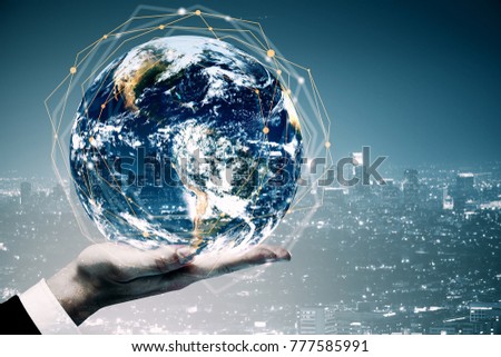 Businessman hand holding globe on abstract city background. International business concept. Double exposure. Elements of this image furnished by NASA 