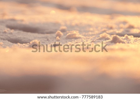 Photo background, macro snow in sunset light. Blurred golden and violet backdrop. Ice decor