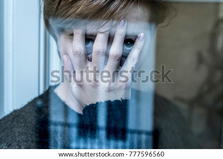 dramatic close up portrait of young beautiful woman thinking and  feeling sad suffering depression at home window looking depressed and worried in lifestyle and life problems concept