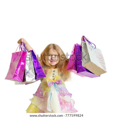 Kids shopping. Children shopping. Happy smiling little girl with shopping bags and gifts. Sale, holidays, fashion, shopping concept. Isolated on white background