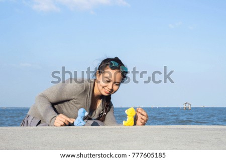 Happiness women using camera for take photo with smile and standing on the riverfront with blue sky and blue ocean on the background. Hipster lifestyle, youth lifestyle, travel and good life concept. 