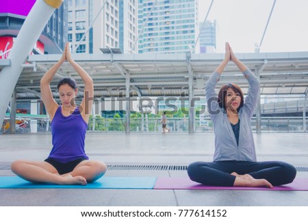 Woman is meditation for yoga. They are yoga in town.Photo concept yoga and good health.
