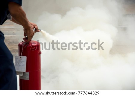 A man practises how to use a fire-extinguisher Royalty-Free Stock Photo #777644329