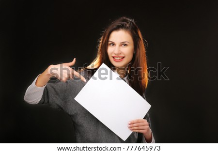 Young woman showing on empty blank board. Isolated on black background. Space for text