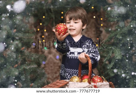 A little child by the New Year tree. Children decorate the Christmas tree