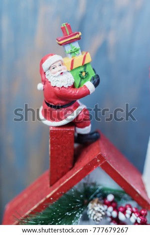 miniature figure Santa claus climb on roof chimney as christmas celebration concept.