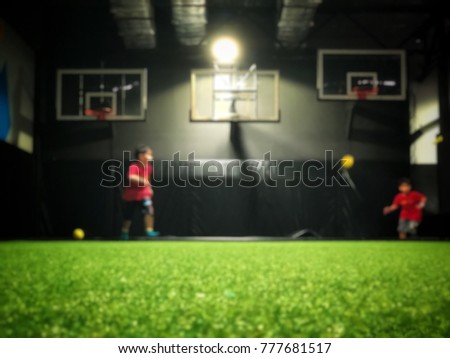 Blurred picture of indoor court ,background is two little boys enjoy playing basketball in weekend.