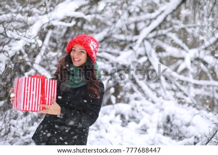 Winter fairy tale, a young mother and her daughter ride a sled in the forest. A girl on a sled with gifts on the eve of the new year in the park. Two sisters walk in a New Year's park and ride a sled