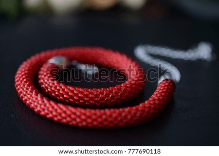 Red bead crochet necklace a dark background close up