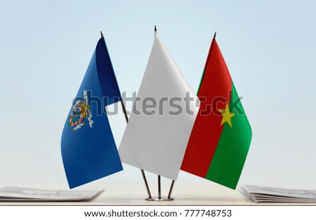Flags of Melilla and Burkina Faso with a white flag in the middle