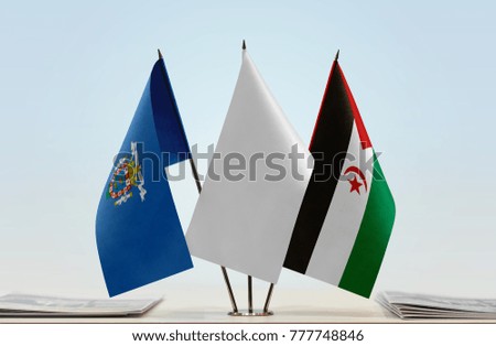 Flags of Melilla and Sahrawi Arab Democratic Republic with a white flag in the middle