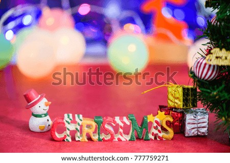 Christmas letter decoration with snowman and presents on bokeh light