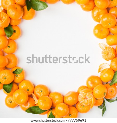 Christmas  tangerine mood!) Wreath made of  fresh small tangerines and green leaves on white wooden background. The best xmas celebration background.  
Flat lay, top view, copy space. 