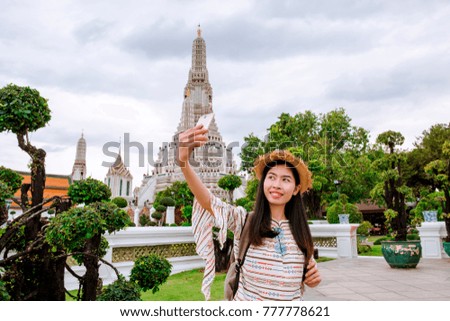 Beautiful Asian woman selfie with smartphone at wat Arun temple on vacation