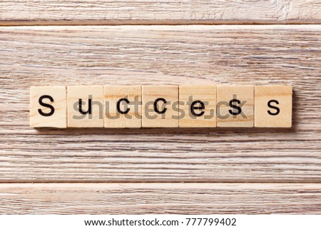 Success word written on wood block. Success text on table, concept.