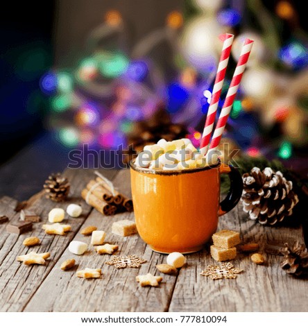a cup of Christmas hot cocoa with marshmallow on the background of New Year's lights and decorations, selective focus