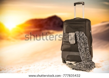 Winter landscape of mountains and black suitcase 