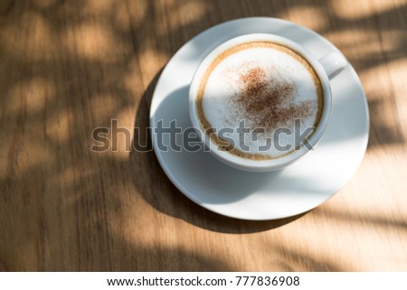 Top view of Cappuchino hotcoffee in a white cup on wooden background.
