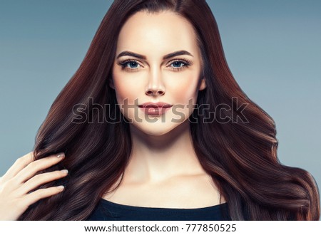 Beauty Woman face Portrait. Beautiful Spa model Girl with Perfect Fresh Clean Skin. Brunette female looking at camera and smiling on gray background. Beautiful hairstyle Youth and Skin Care Concept