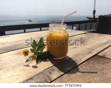 Yellow mango smoothie with ocean view