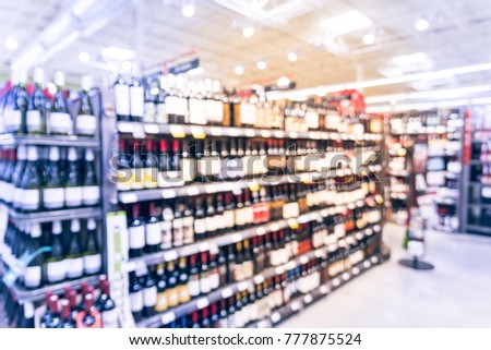 Blurred of wine bottles on display at store in Irving, Texas, US. Defocused image shelves and price tags. Rows of liquor on supermarket shelf. Alcoholic beverage abstract background. Vintage tone