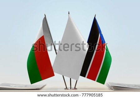 Flags of Madagascar and South Sudan with a white flag in the middle