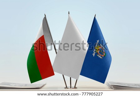 Flags of Madagascar and Melilla with a white flag in the middle