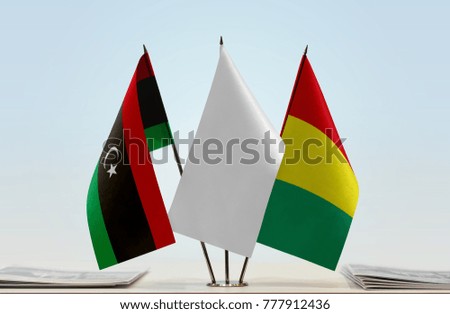 Flags of Libya and Guinea with a white flag in the middle