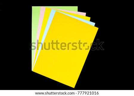 green, pink, yellow, blue and orange paper isolated on black background