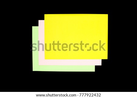 green, pink and yellow paper isolated on black background