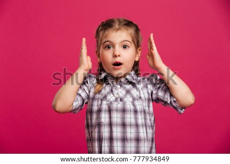Picture of shocked little girl child standing isolated over pink background. Looking camera.