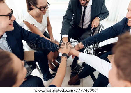 Collective work of full-fledged people and people with disabilities. Persons with disabilities in everyday life. Work disabled businessman. Teamwork with people in wheelchairs. Royalty-Free Stock Photo #777948808