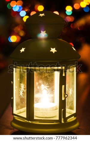 Lamp with candles on a background of Christmas lights