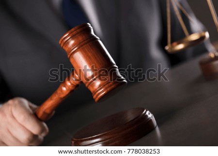 Man in suit, striking gavel. Lawyer concept.