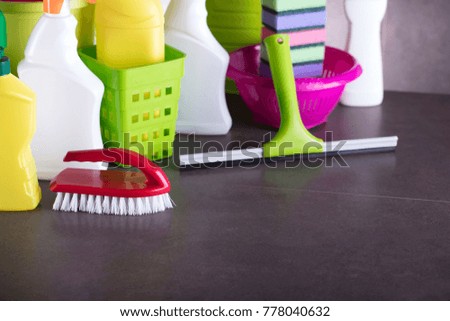 Various house cleaning products. Gray tiles. Place for text.