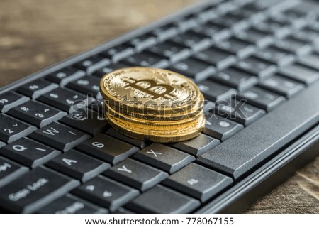 Black keyboard with pile of golden coins with Bitcoin sign.