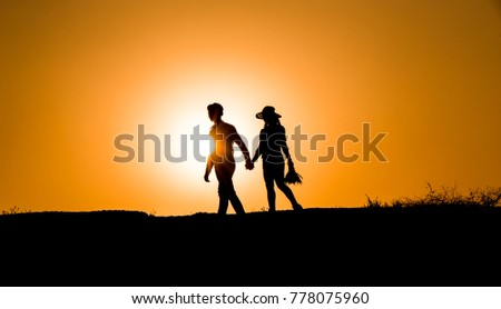 Silhouette of a couple sharing a romantic moment at suns, young man gives flowers to his lover, young lover silhouette at sunset