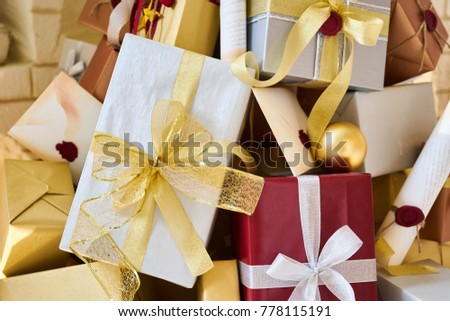 Stack of Christmas and New Year Gift Boxes in Silver Gold and Red Color Decorated with Christmas Ornament Letter and Paper