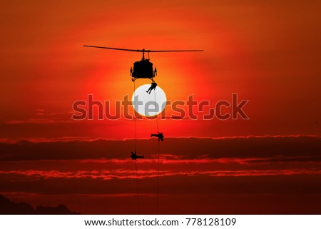 silhouette of helicoptor rescue at sunset.