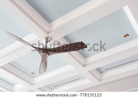 A Large Interior Fan on a Blue Coffered Ceiling Royalty-Free Stock Photo #778135123