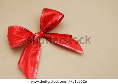 Christmas red bow  isolated on brown background, copy space. 