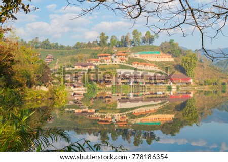Ban Rak Thai village with cloudy sky reflected in mirror lake.Mae Hong Son Province,Northern Thailand.