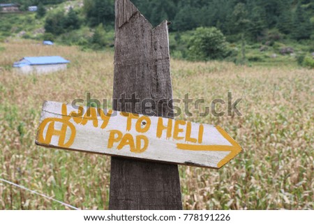 Wooden signboard with text written Way To Helipad, Lukla Nepal