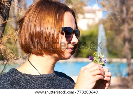 Young woman with field flowers. Portrait of brunette girl in nature.