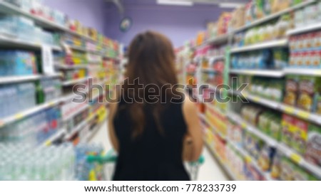 Abstract blurred photo of Lady shopping in the supermarket.
